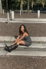 Vestido corto de corte ajustado con escote tipo bustier y tirantes finos. Presenta costuras verticales que definen la silueta y cierre posterior con cremallera oculta.