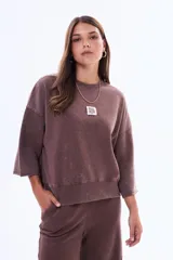 Buzo de felpa con friza, de corte holgado y diseño minimalista. Presenta cuello redondo, mangas cortas con terminación al corte y un pequeño parche rectangular en el pecho con la inscripción 'SELF LOVE CLUB'.