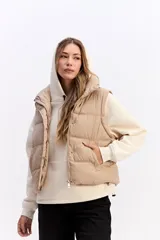 Chaleco matelaseado de color negro, con cuello alto, cierre frontal con broches y diseño acolchado con volumen.