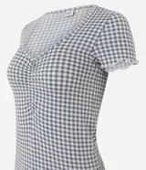 Pijama corto de dos piezas de la marca Lov, confeccionado en tejido peach touch de poliéster y elastano. Incluye una remera de manga corta con escote redondo, detalle de frunce en el busto y terminaciones con volados, acompañada de un short con cintura elástica y diseño estampado a cuadros vichy en tonos gris y blanco.
