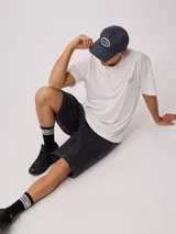 Gorra de lona lavada color beige con visera azul marino y parche bordado con el logo de Rusty.