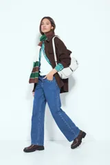 Jean de corte recto y silueta relajada, confeccionado en denim azul. Presenta una hilera de tachas metálicas decorativas a lo largo de los laterales de ambas piernas.