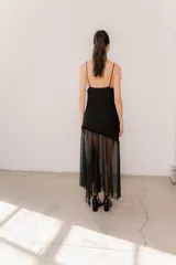 Vestido midi color marrón con breteles finos y escote en V. Presenta un diseño asimétrico en el cuerpo con detalles en terciopelo negro y una falda de microtul transparente.