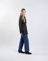 Campera tipo trench negra a la cadera, con solapa cruzada, doble botonadura frontal, hombreras y bolsillos delanteros con solapa.