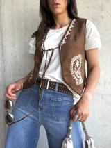 Chaleco marrón de gamuza con bordados florales en color crema, con cierre frontal con lazos.