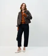 Campera de gamuza sintética color tostado con botones dorados grabados, cuello camisero, bolsillos frontales aplicados y mangas largas con puños abotonados.