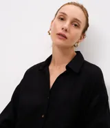 Vestido largo chemise negro de Marfinno, confeccionado en mezcla de lino y viscosa. Presenta diseño recto, cuello camisero, botonadura frontal completa, bolsillos laterales y mangas largas con puños.