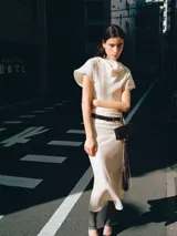 Vestido midi color crudo, con cuello drapeado, mangas cortas holgadas y diseño recto.