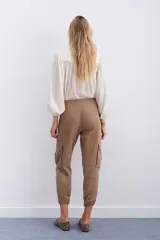 Pantalón de corderoy gris, de fit holgado con elástico en cintura y puños. Presenta bolsillos aplicados en el delantero.