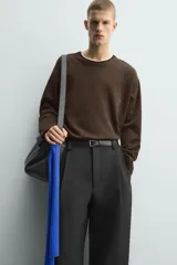 Camiseta de manga larga y corte relajado en color marrón oscuro. Presenta un diseño de doble capa en el cuello y el ruedo, con un borde interior en color blanco que crea un efecto de contraste.