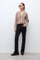 Remera de manga larga color tostado con escote en V y detalles de vivos en contraste color negro que recorren el frente y los laterales de las mangas.