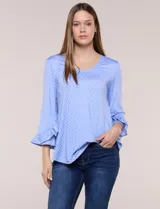 Blusa celeste con estampado de lunares blancos, cuello en V y mangas 3/4 terminadas en volados.