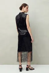 Falda larga negra de lentejuelas con terminación en flecos.