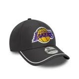 Gorra New Era gris oscuro con el logo de Los Angeles Lakers bordado en el frente. Tiene visera curva con borde blanco, corona estructurada y cierre ajustable en la parte posterior.