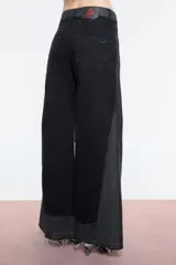 Pantalón de jean negro con corte wide leg y tiro alto. Diseño con dos tipos de denim, uno negro y otro gris, con recortes que resaltan la variación de telas.