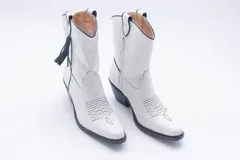 Botas estilo texanas de caña media, confeccionadas en cuero con estampado animal print tipo vaca en blanco y negro. Presentan un diseño de punta fina y taco cuadrado.
