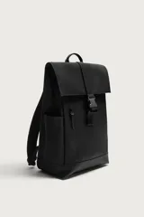 Mochila de diseño minimalista en acabado engomado color negro. Cuenta con compartimento principal con cierre de solapa y hebilla de liberación rápida, bolsillo frontal con cierre, compartimento interno para dispositivos electrónicos y espalda acolchada con banda de sujeción para equipaje.