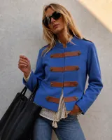 Chaqueta azul estilo militar confeccionada en algodón, con cuello mao, apliques horizontales de cuerina marrón en el frente con botones dorados y trabillas en los hombros.