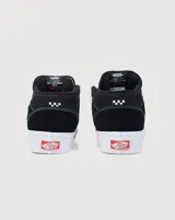 Championes de skate Vans modelo Half Cab, de corte medio, confeccionados en gamuza y lona color negro con costuras blancas. Presentan suela de goma blanca vulcanizada, cordones blancos y etiqueta distintiva en el lateral y la lengüeta.