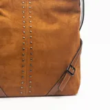 Cartera de hombro color marrón, confeccionada en gamuza, con detalle de tachas metálicas verticales en el centro y correas laterales decorativas con hebillas.