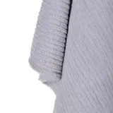 Poncho de tejido de punto en color gris, con textura acanalada diagonal y cuello alto.