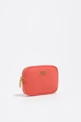 Monedero coral de Bimba y Lola con cierre de cremallera metálica dorada, detalle de logotipo metálico en el frente y bolsillo interior.