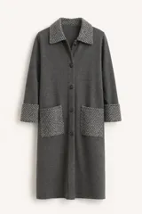 Tapado de punto color gris oscuro con cierre frontal de botones. Presenta cuello, puños y bolsillos frontales en tejido texturizado con patrón de espiga en tonos gris y negro.