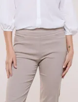 Pantalón de gabardina elastizada color beige, de tiro medio y calce slim. Cuenta con diseño pull-on sin cierres ni botones, cintura ancha, bolsillos delanteros simulados y bolsillos traseros ojal.