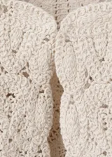 Chaqueta de punto grueso color beige con diseño de encaje en relieve, cuello redondo y cierre frontal.