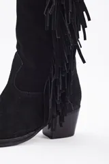 Bota bucanera de caña alta confeccionada en cuero vacuno, con diseño de estilo western que presenta flecos laterales largos y taco cuadrado.