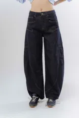 Jean de corte wide leg y tiro alto, confeccionado en denim de color azul oscuro. Presenta costuras decorativas visibles en los laterales y un diseño de pierna amplia.