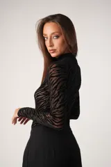 Pantalón sastre negro de corte ancho con pinzas en la cintura y bolsillos laterales.