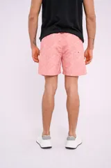 Short de baño color salmón con estampado de estrellas de mar blancas, cordón ajustable en la cintura y bolsillos laterales.