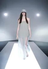 Vestido largo color gris claro, de corte recto con diseño transparente y superposición de tiras decorativas con argollas plateadas en los tirantes.