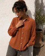 Camisa de diseño clásico con cuello camisero, mangas largas con puño elastizado y cierre de botones al frente.