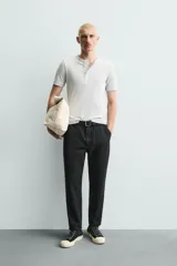 Pantalón de corte carrot fit confeccionado en tejido de algodón con estructura diagonal y efecto lavado. Presenta bolsillos frontales con bolsillo cerillero, bolsillos traseros de plastrón y cierre frontal con cremallera y botón.