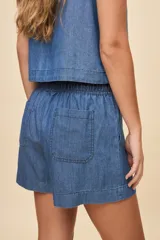 Short de calce relajado en denim azul, con cintura elastizada, cordón ajustable, bolsillos delanteros aplicados y ruedo ancho.