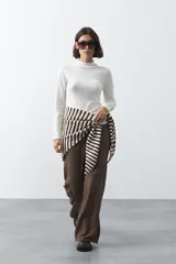 Polera de tejido de punto color celeste, con cuello alto y textura de pequeños puntos en relieve formando una cuadrícula en el frente y las mangas. De corte ajustado y manga larga.