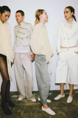 Jeans de tiro alto, corte ancho y pierna recta, color beige claro con efecto lavado. Presenta trabillas en la cintura, bolsillos delanteros y traseros, y cierre frontal con cremallera y botón.