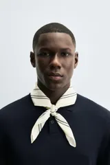 Pañuelo cuadrado de algodón color beige/tostado con doble borde cosido en hilo negro contrastante.