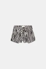 Shorts de tiro bajo con estampado de cebra en blanco y negro. Presenta cintura ajustable con cordones anudados al frente.