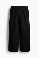 Pantalón de jogging de felpa de algodón pesado, con corte de pierna ancha y silueta relajada. Presenta cintura elástica con cordón ajustable, bolsillos laterales al bies y un bolsillo de parche en la parte trasera.