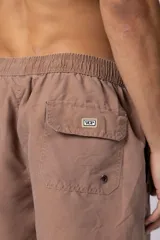 Short de baño de corte clásico con cintura elástica y cordón ajustable. Presenta un acabado efecto lavado vintage, bolsillos laterales y un pequeño logo bordado en la parte inferior.