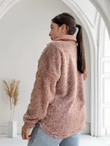 Campera de abrigo tipo teddy color camel, con cierre frontal y bolsillo de cuero sintético en el pecho.