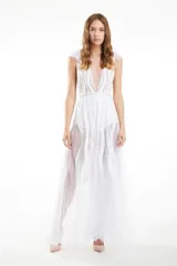Vestido largo de tul blanco con escote profundo en V, sin mangas y falda con paneles transparentes y detalles bordados verticales. Presenta una cintura definida y caída fluida.