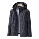 Campera cortaviento impermeable de la marca Uniteduy, color negro con estampado sutil de hojas. Cuenta con capucha, cierre frontal, tres bolsillos externos y uno interno. Es una prenda ultra liviana y transpirable, ideal para actividades al aire libre.