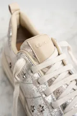 Zapatillas plateadas con apliques de estrellas negras, de cuero legítimo.