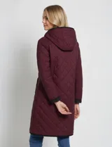 Campera reversible de corte largo con diseño capitoneado. Un lado presenta un tono verde oliva y el otro un tono negro, ambos con cierre frontal mediante botones a presión y bolsillos laterales.