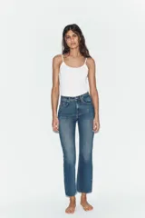 Jeans de tiro alto con diseño cropped flare, confeccionados en denim azul con acabado desgastado. Presentan cinco bolsillos, cierre frontal con cremallera y botón metálico, y bajo con terminación sin costuras.