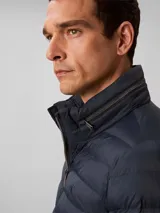 Campera puffer de peso medio Calvin Klein, con diseño acolchado, cuello alto y cierre frontal de cremallera. Presenta un logo sutil estampado en el pecho y está confeccionada en nailon reprocesado.